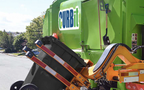 Automated garbage truck lifting a garbage cart.